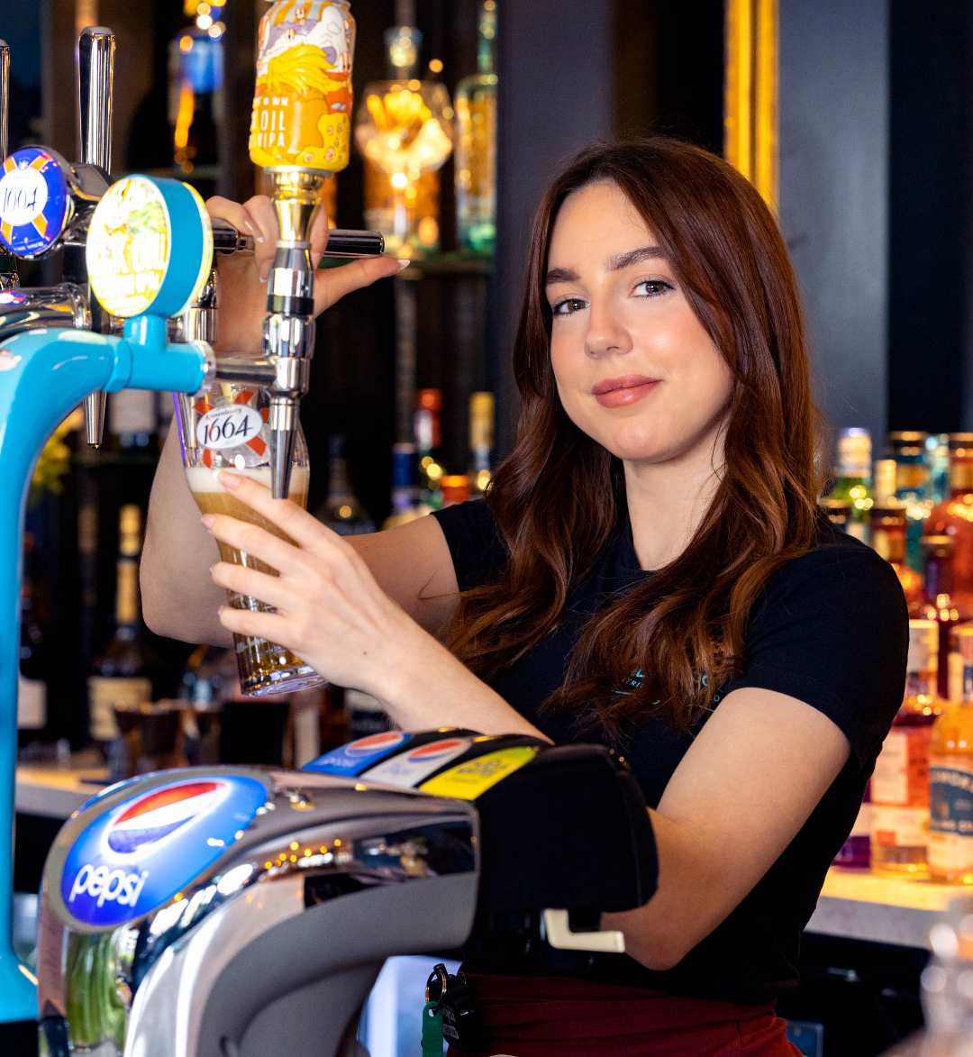 Barmaid pouring a fresh pint of 1664